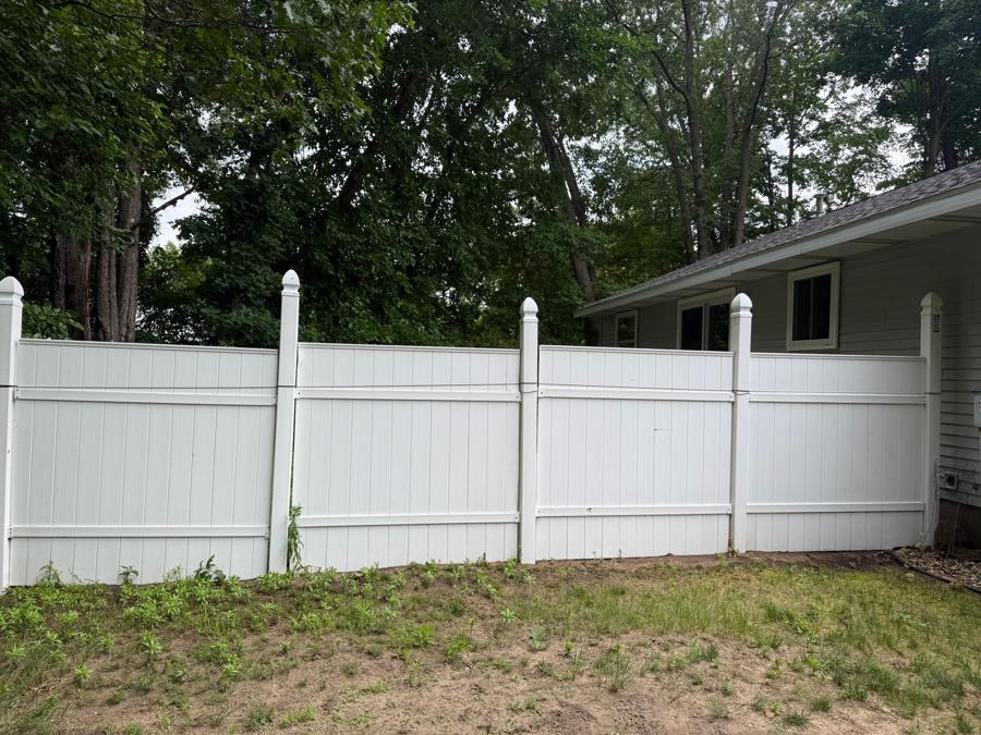 Bright white vinyl privacy fence after pressure washing in Grand Haven, Michigan