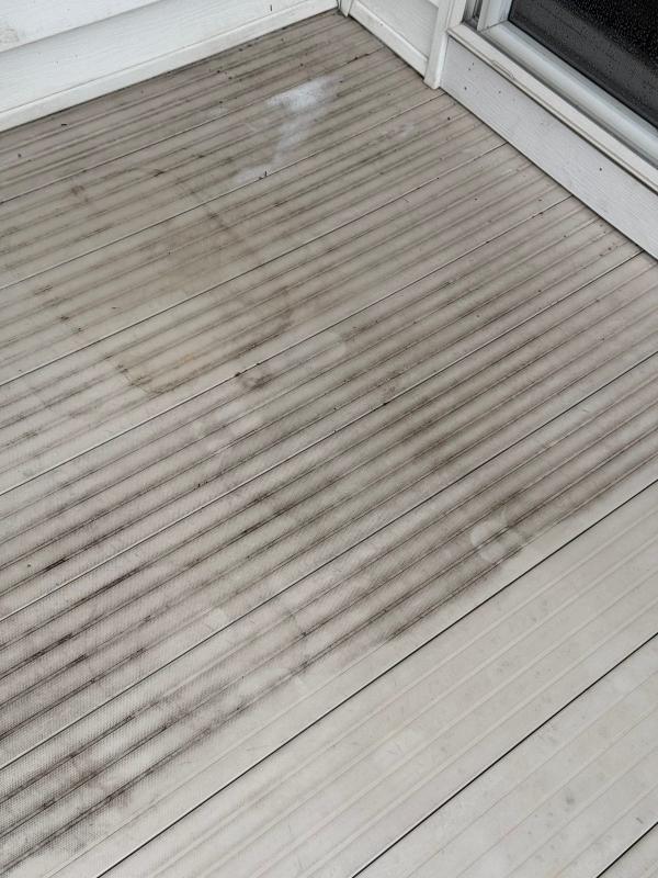 Weathered composite deck with algae and mildew buildup before pressure washing